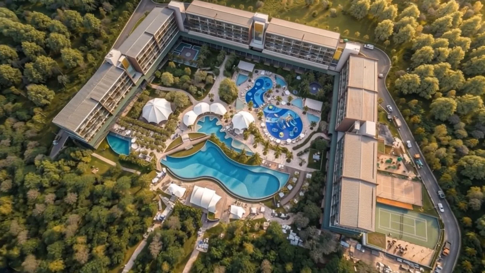 Perspectiva aérea de empreendimento com edifícios e piscinas